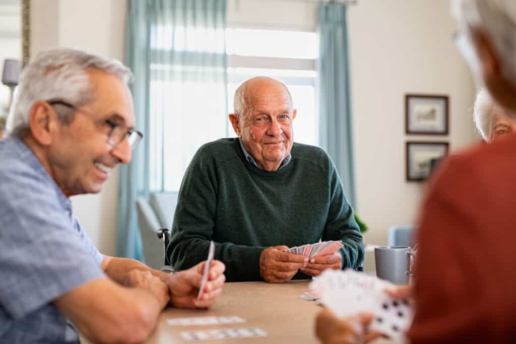Retired Senior Man Playing Cards With Friends At Senior Community